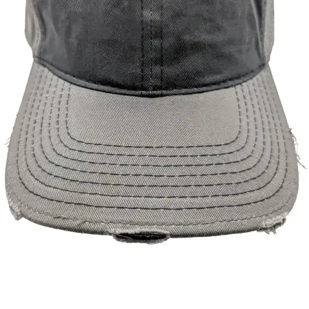 Photo of a cap visor with purposely frayed and worn spots
