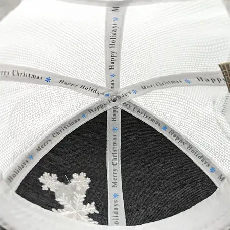 Photo of the fabric taping strips on the inside of a cap crown with custom text screen printed along them